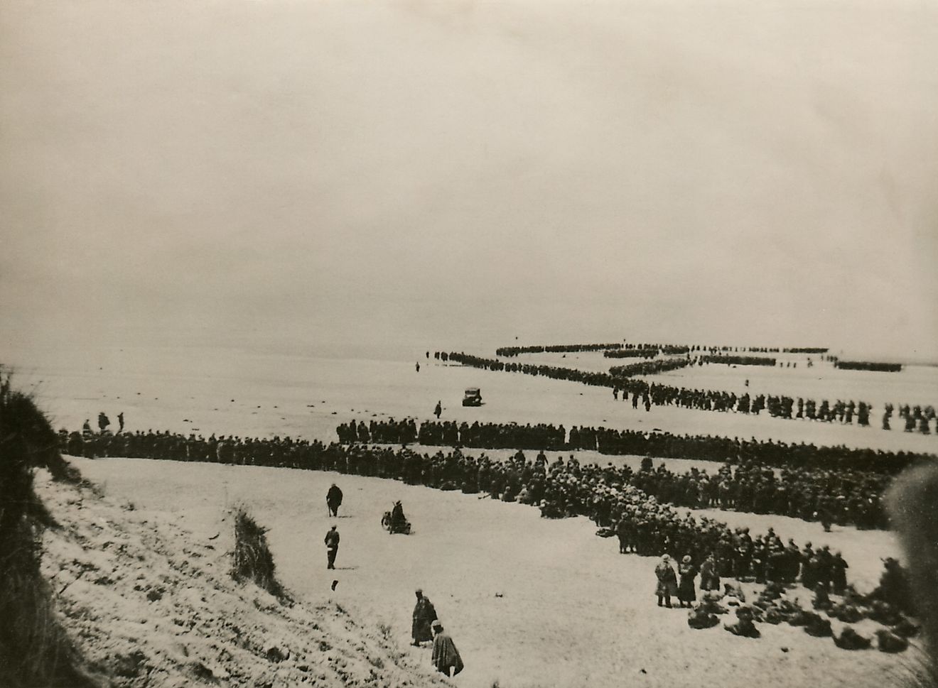 Military evacuation of Dunkirk during World War 2. Thousands of British and French troops wait on the dunes of Dunkirk beach for transport to England.
