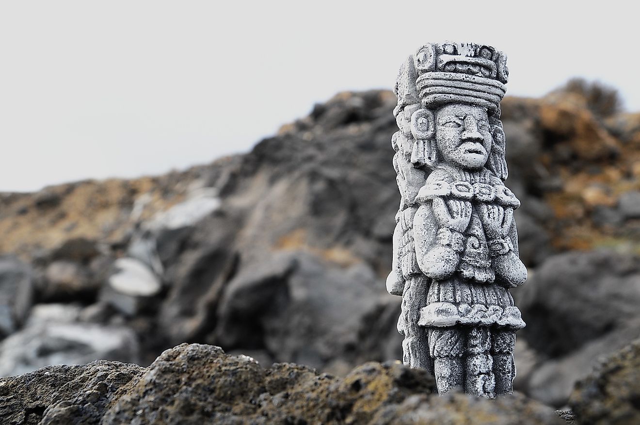 Ancient Maya statue on the rocks along the sea. Image credit: Underworld/Shutterstock.com