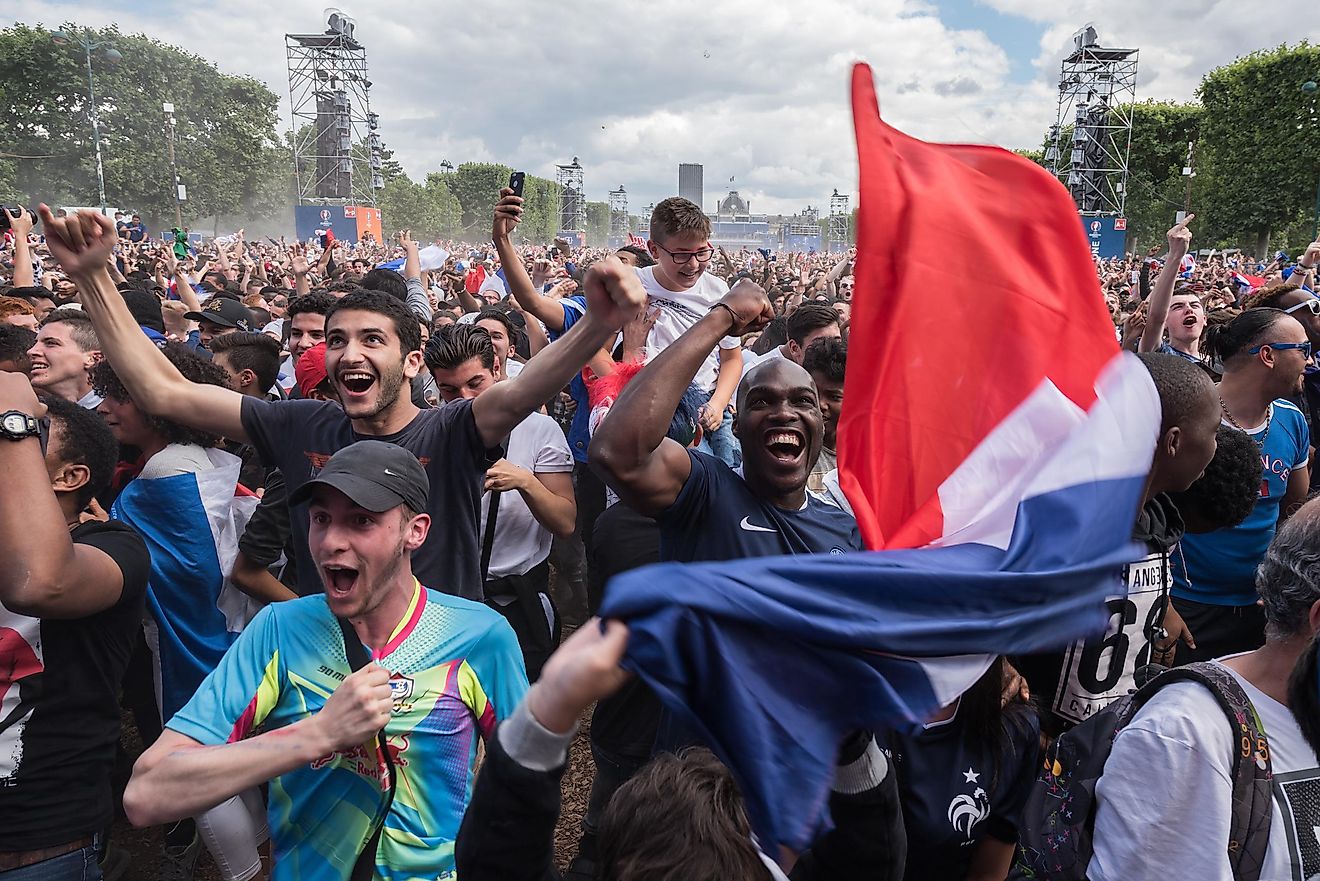 Crowd of happy supporters inside the fan zone of the Eiffel Tower during the match between France and Ireland for the Euro 2016. Credit: Frederic Legrand - COMEO / Shutterstock.com