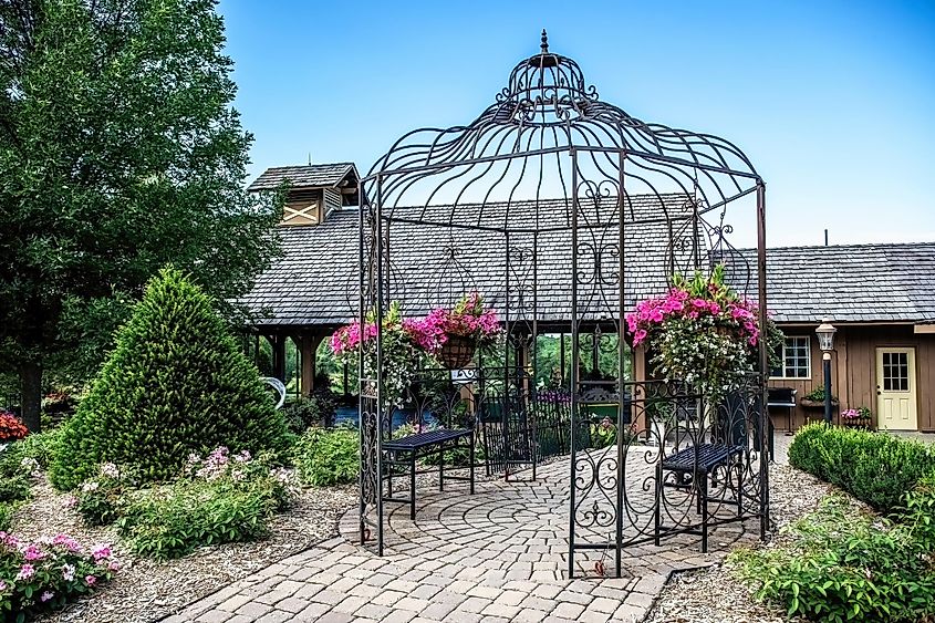 Pretty iron garden gazebo with potted flowers at Panola Valley Gardens, a wedding venue, in Lindstrom, Minnesota, USA. Editorial credit: Linda McKusick / Shutterstock.com