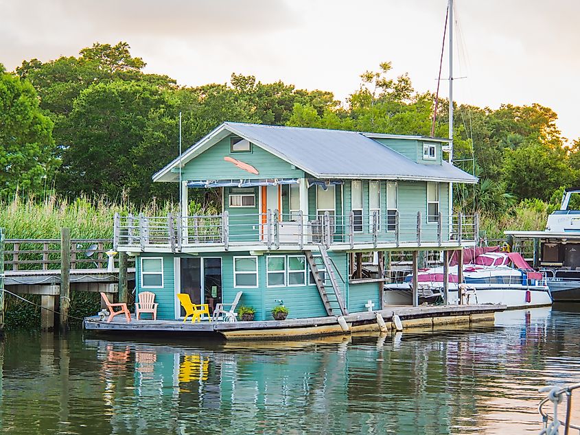 A colorful houseboat residence docked on Apalachicola Bay in the town of Apalachicola, Florida, via Leigh Trail / Shutterstock.com