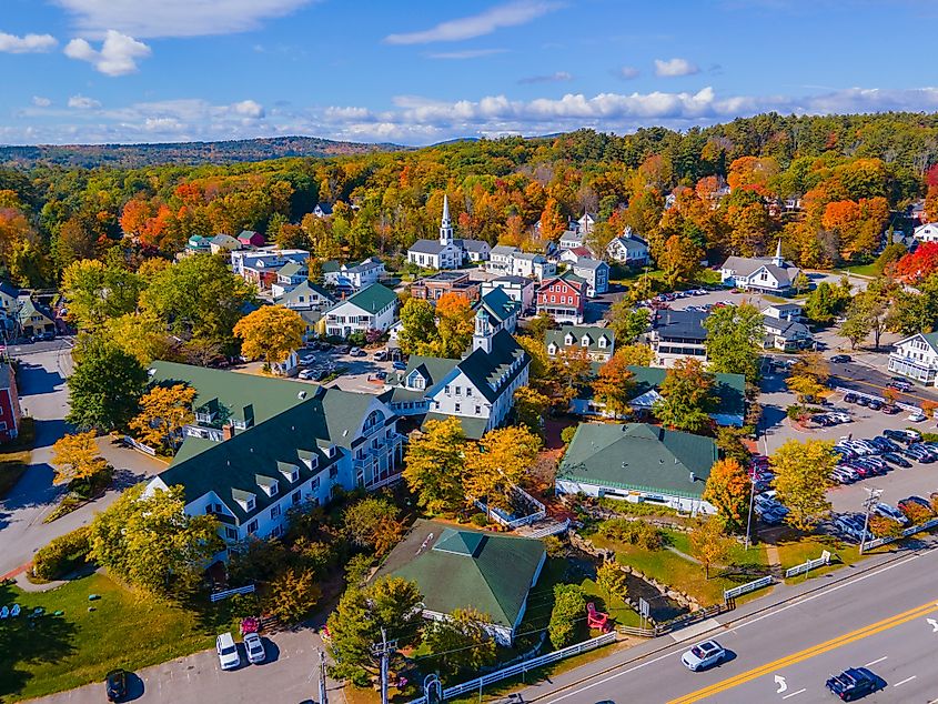 Aerial view of Meredith town center with fall foliage, including First Congregational Church and Mill Falls, Meredith, New Hampshire, USA.