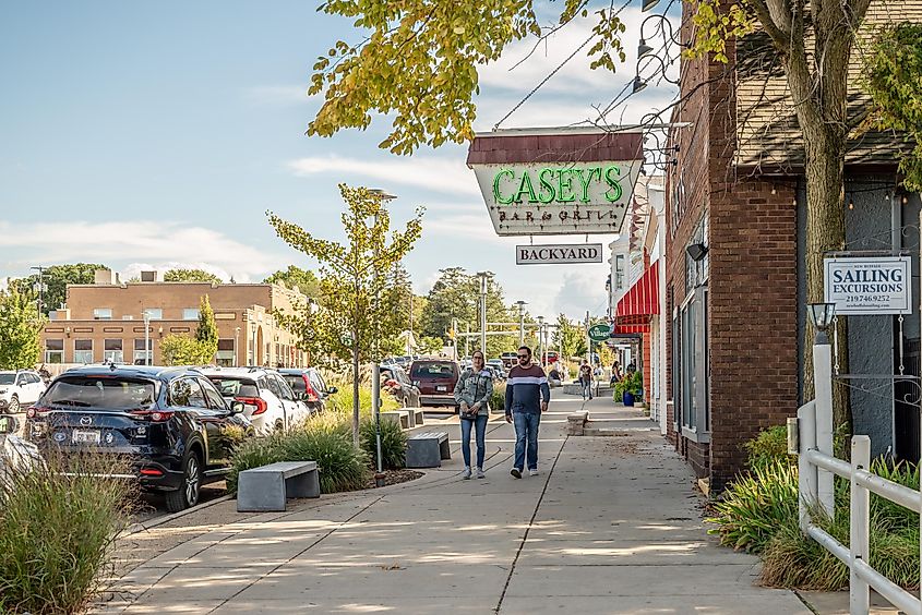 People explore the quaint downtown area of New Buffalo, Michigan, passing Casey's Diner.