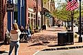 A thin, blonde woman takes a picture of two friends seated at a sidewalk table in front of the Downtown Sweet coffee shop. Editorial credit: Nolichuckyjake / Shutterstock.com