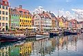 Many popular restaurants, cafes and bars in the old colorful houses on the Nyhavn waterfront in Copenhagen, Denmark. Image credit chernobrovin via Shutterstock.