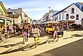 Vacationers take on Market Street on Mackinac Island that is lined with shops and restaurants. Image credit Alexey Stiop via Shutterstock.