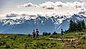 Three hikers walk a trail along Sunrise Point at North Cascades National Park with the Cascade Range in the background. Editorial credit: arthurgphotography / Shutterstock.com