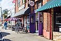 Sidewalk scene with people sitting at tables in front of East Frank's Superette Kitchen in Monroe, NC. Image credit Nolichuckyjake via Shutterstock.