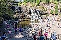 Gooseberry Falls, a popular waterfall near Duluth, Minnesota, attracts a crowd of visitors on a summer day. Editorial credit: melissamn / Shutterstock.com