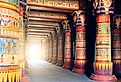 Colorful Ancient Egyptian writing on stone pillars in Egypt, lining a pathway to a bright entryway.