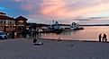 City of Lake Geneva, WISCONSINUSA-September 18, 2022: People gathering at the beach near Lake Geneva, showing the boat docks during a gorgeous pinky and cloudy sunset