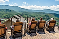 Tourists sit on the outdoor chairs at Gatlinburg Skydeck, facing the best view of the Great Smoky Mountains on a sunny day. Editorial credit: Chansak Joe / Shutterstock.com