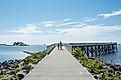 A view down the pier boardwalk on a beautiful summer day by the Long Island Sound at calf pasture beach in Norwalk, Connecticut