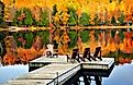 Wooden dock with chairs on calm fall lake. Image credit Elena Elisseeva via shutterstock