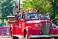 Elderly twins ride in an old-fashioned fire truck in the Double Take Parade, in Twinsburg, Ohio. Image credit Kenneth Sponsler via Shutterstock