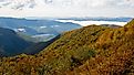 Clouds hanging over North Carolina's Blue Ridge Mountains, part of the Appalachians, near Asheville and Charlotte, with vibrant fall foliage and close proximity to the borders with South Carolina, Georgia, Tennessee, and Virginia.