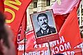 The flag of the Soviet Union (USSR) waving in the wind against the background of the monument to Lenin.