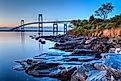 Newport Bridge Sunrise / This is a long exposure HDR of the illuminated Newport bridge from Taylor's Point near Jamestown, Rhode Island, USA. Taken at sunrise with rocky seascape in foreground.