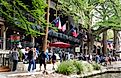 San Antonio, Texas: Visitors walking next to the bars and restaurants along the river walk, via Khairil Azhar Junos / Shutterstock.com