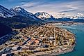 Aerial view of Seward, Alaska, in early summer, with the town nestled between the mountains and Resurrection Bay