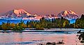 Sunrise on Mount Foraker and Mount Hunter across the Susitna River with fall foliage. 