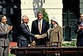 Yitzhak Rabin of Israel and Yasser Arafat of the PLO shake hands on the South Lawn of the White House after signing the Peace Accords, while President Bill Clinton stands behind them. Editorial credit: mark reinstein / Shutterstock.com