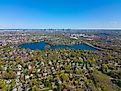 Aerial view of Arlington Heights suburban landscape in spring with Spy Pond and Boston modern city skyline at the background in the historic town of Arlington, Massachusetts