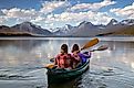 Adventurous traveling couple rowing a boat on a perfect scenic lake in Montana. 