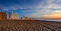 Virginia Beach, Virginia at sunset with lights on the boardwalk and buildings in the background. Image credit jomo333 via AdobeStock.