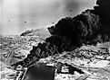 Smoke rises from oil tanks beside the Suez Canal hit during the initial Anglo-French assault on Port Said, 5 November 1956.