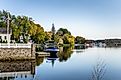 Waterside Houses among Trees with Boats Moored to Wooden Jetties on a Clear Autumn Day