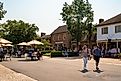 Street scene from historic Williamsburg Virginia at Merchants Square with people visible.