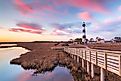 Clouds stream like pink ribbons in the sky over the marsh and lighthouse on Bodie Island on the Outer Banks of North Carolina.