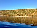 The clear, still waters of the Canadice Lake in New York, during autumn. 