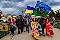 A festive procession of participants of the celebration of the International Roma Day in the city center of Uzhhorod, Ukraine. The flag at the front is the flag of the Romani people. Editorial credit: Yanosh Nemesh / Shutterstock.com