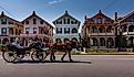 A carriage carries tourists past a row of Victorian "gingerbread" houses typical of Cape May, NJ. Editorial credit: Steve Rosenbach / Shutterstock.com