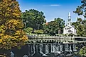 View of white church and waterfall surrounded by trees in Milford, Connecticut