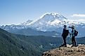 Hikers pause to take photos of Mount Rainier and the surrounding countryside.