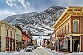 Rustic buildings lined along 6th Street in Georgetown, Colorado, with mountains in the background. Editorial credit: marekuliasz / Shutterstock.com