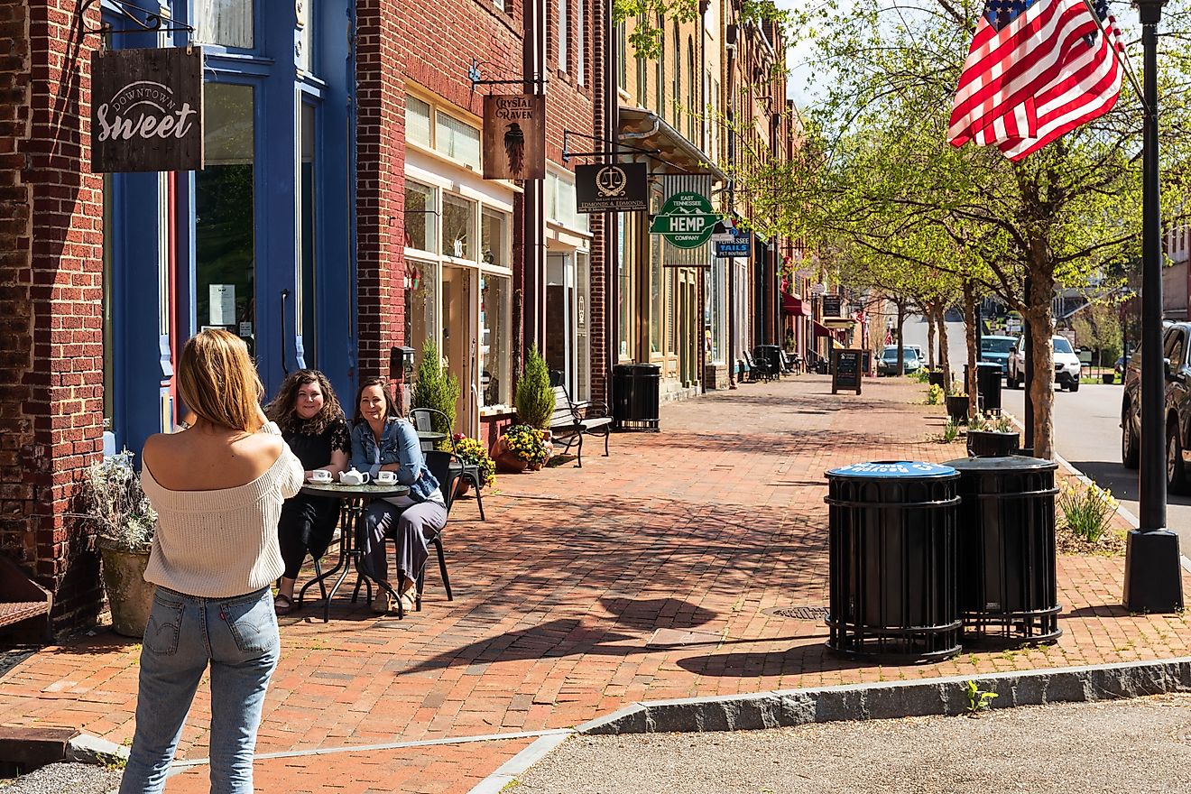 JONESBOROUGH, TN, Woman takes a picture of two friends seated at a sidewalk table, in front of the 'Downtown Sweet' coffee shop. Editorial credit: Nolichuckyjake / Shutterstock.com