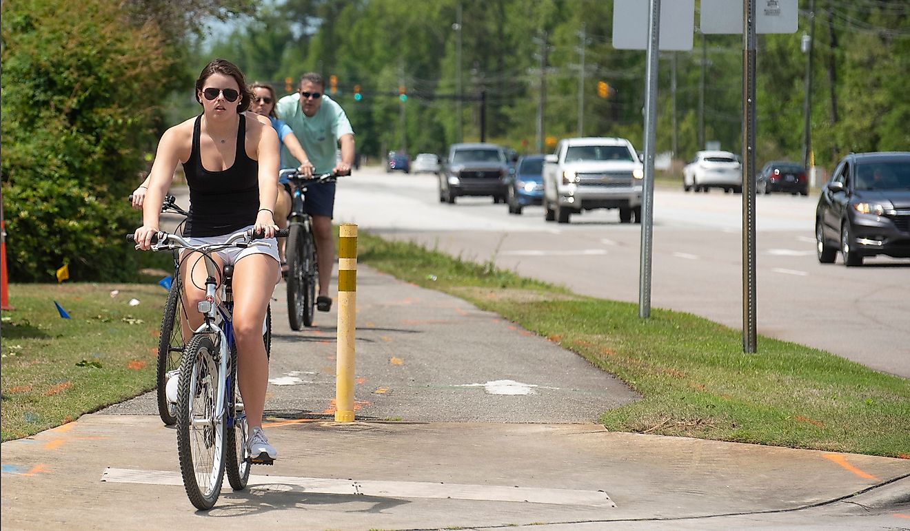 A young woman and her family go for a bike ride near Wrightsville Beach. Editorial credit: Sharkshock / Shutterstock.com