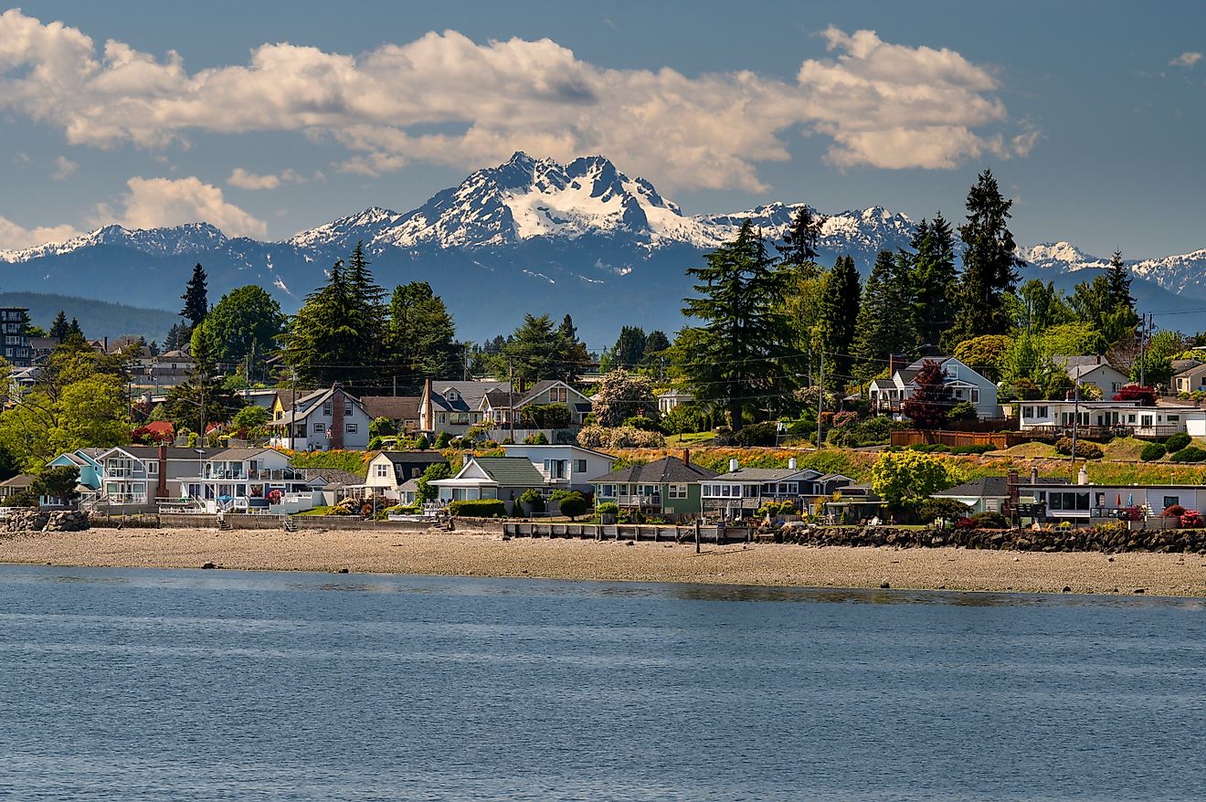 View of the Pacific Coast along the town of Bremerton, Washington, and mountains in the backdrop.