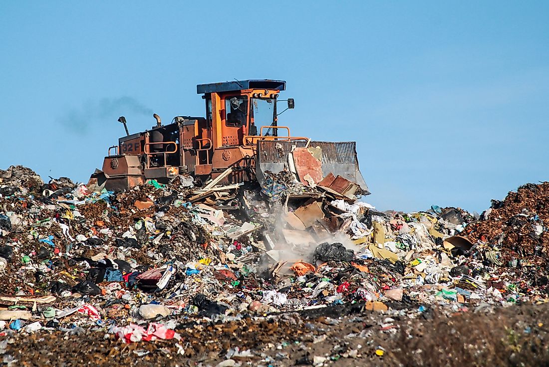A large garbage dump and bulldozer. 