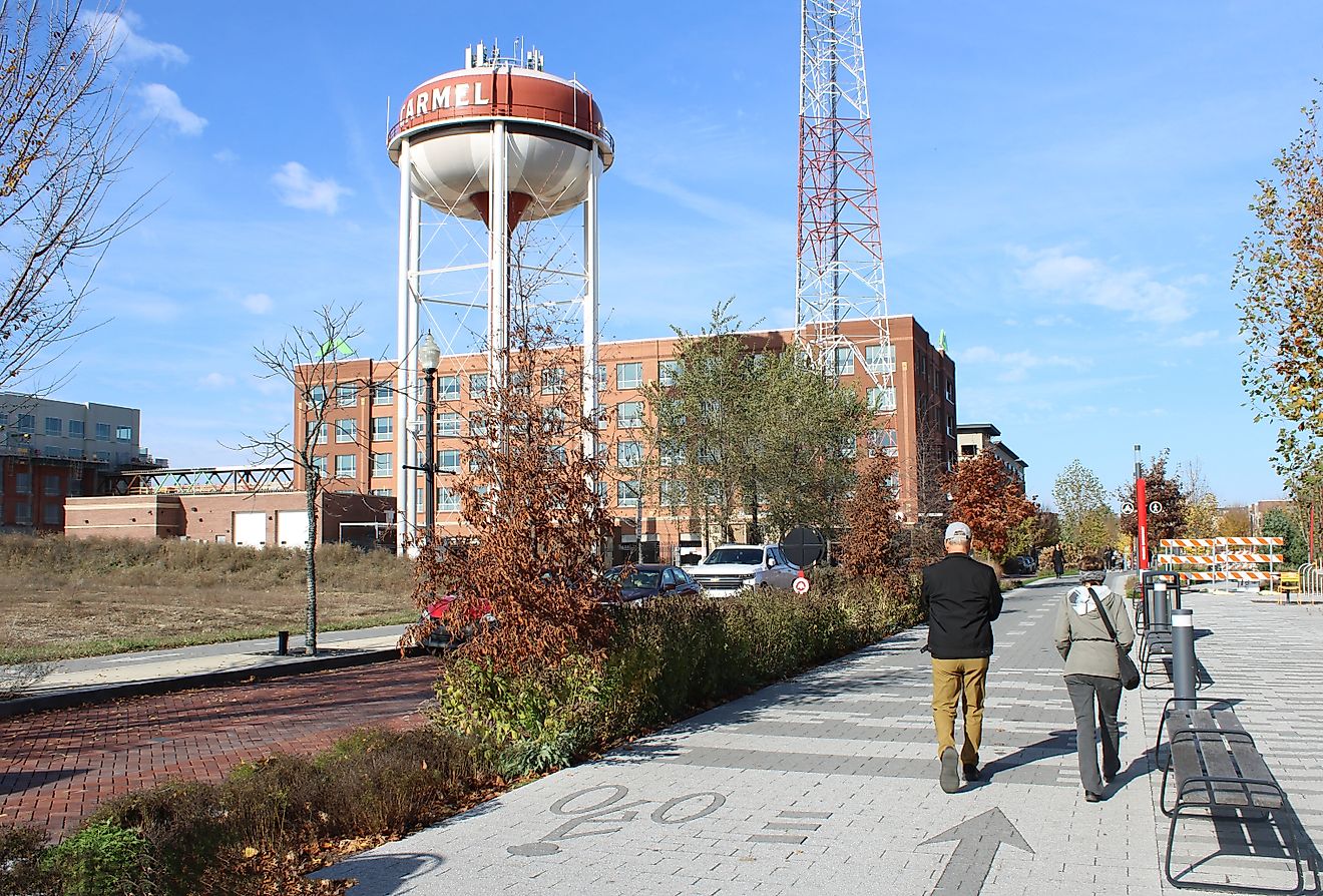 Carmel, Indiana, USA November 24, 2024, Older couple walking on the Monon Greenway Trail with the town water tower in the background