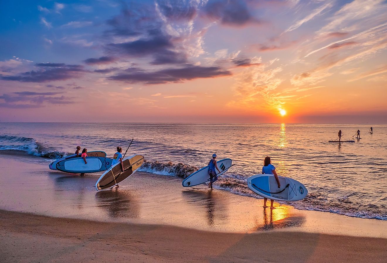 A group of young women take their paddle boards out at sunrise to paddle along the Atlantic Coast. Image credit David Kay via Shutterstock