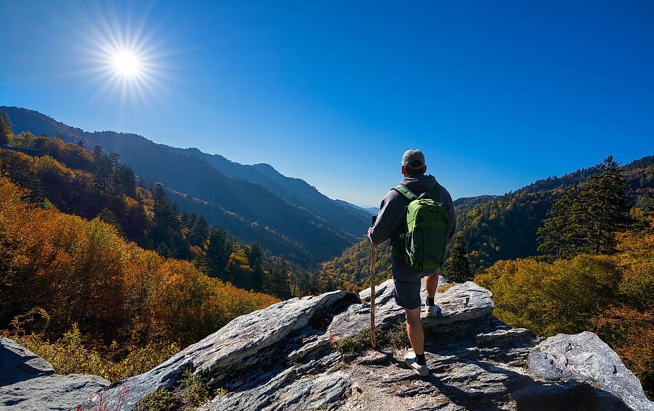 Man relaxing on an autumn hiking trip, standing on top of a mountain and enjoying the beautiful fall scenery in Smoky Mountains National Park, near Gatlinburg, Tennessee, USA