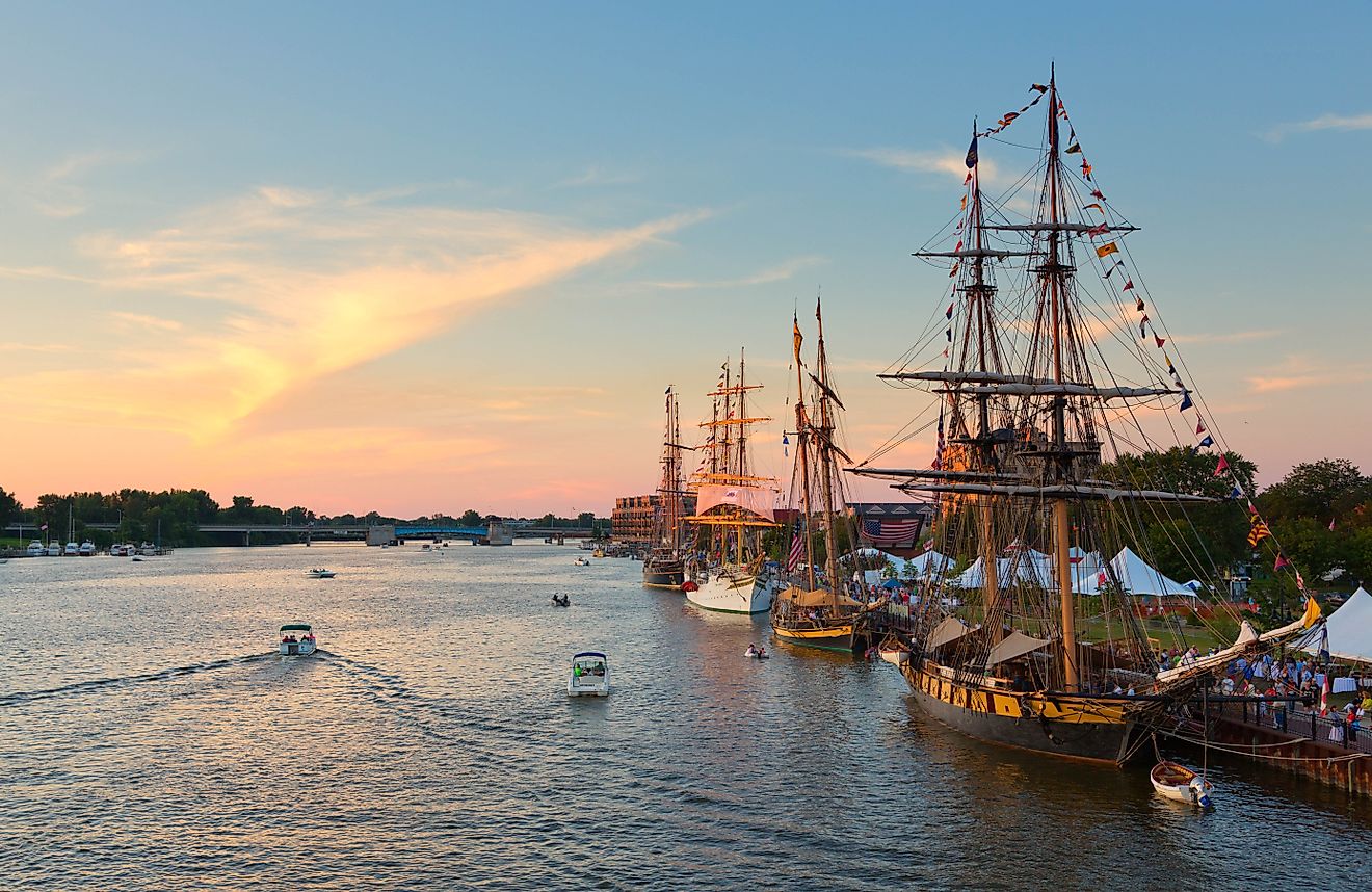 Tall ships line the river's edge at Wenonah Park in Bay City, Michigan, during the Tall Ship Celebration at sunset. Editorial credit: Craig Sterken / Shutterstock.com