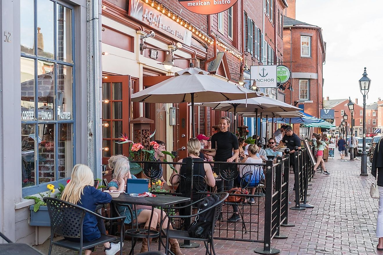 Outdoor dining on the streets of downtown Newburyport, MA, USA, featuring quaint streets with 19th-century brick buildings and trendy shops and restaurants. Editorial credit: Heidi Besen / Shutterstock.com