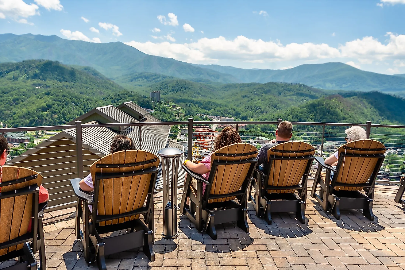 Tourists sit on the outdoor chairs at Gatlinburg Skydeck, facing the best view of the Great Smoky Mountains on a sunny day. Editorial credit: Chansak Joe / Shutterstock.com