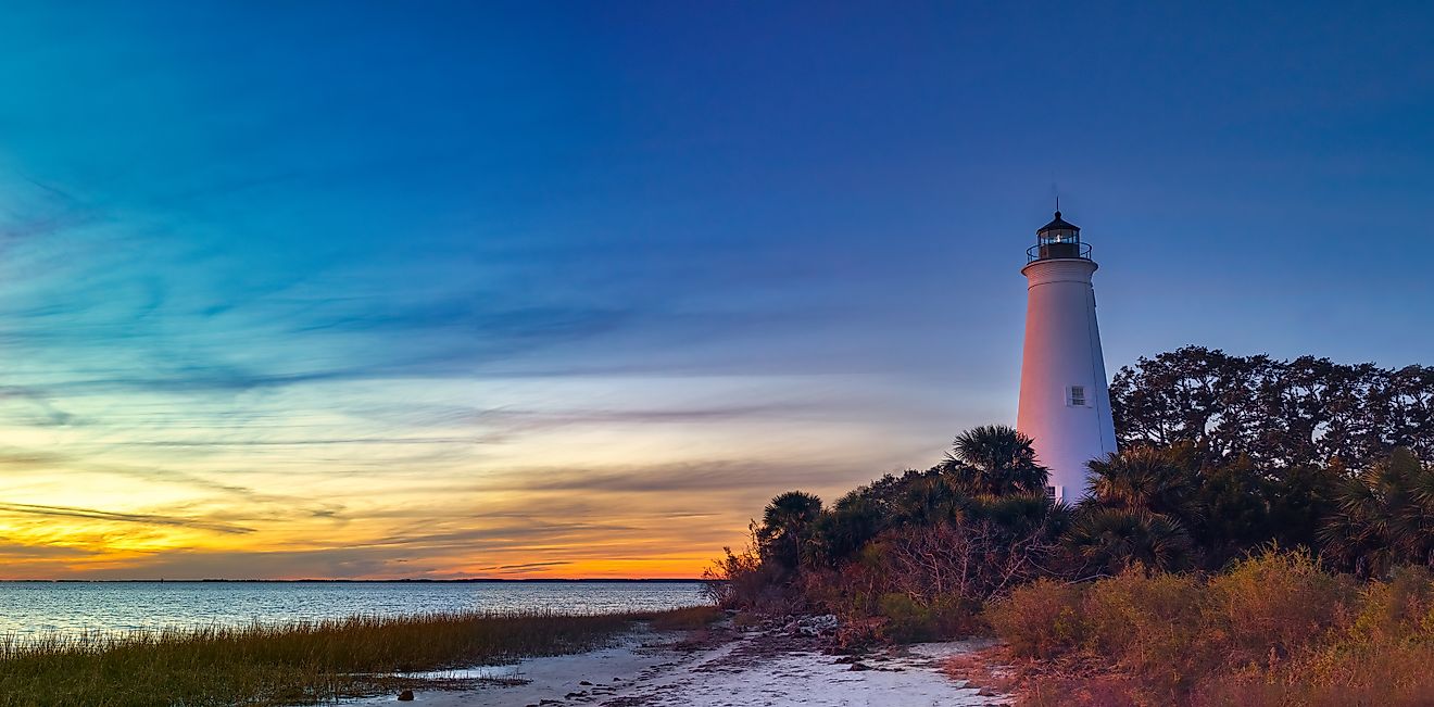 St. Marks Lighthouse at St. Marks Wildlife Refuge, silhouetted against a glowing sunset.